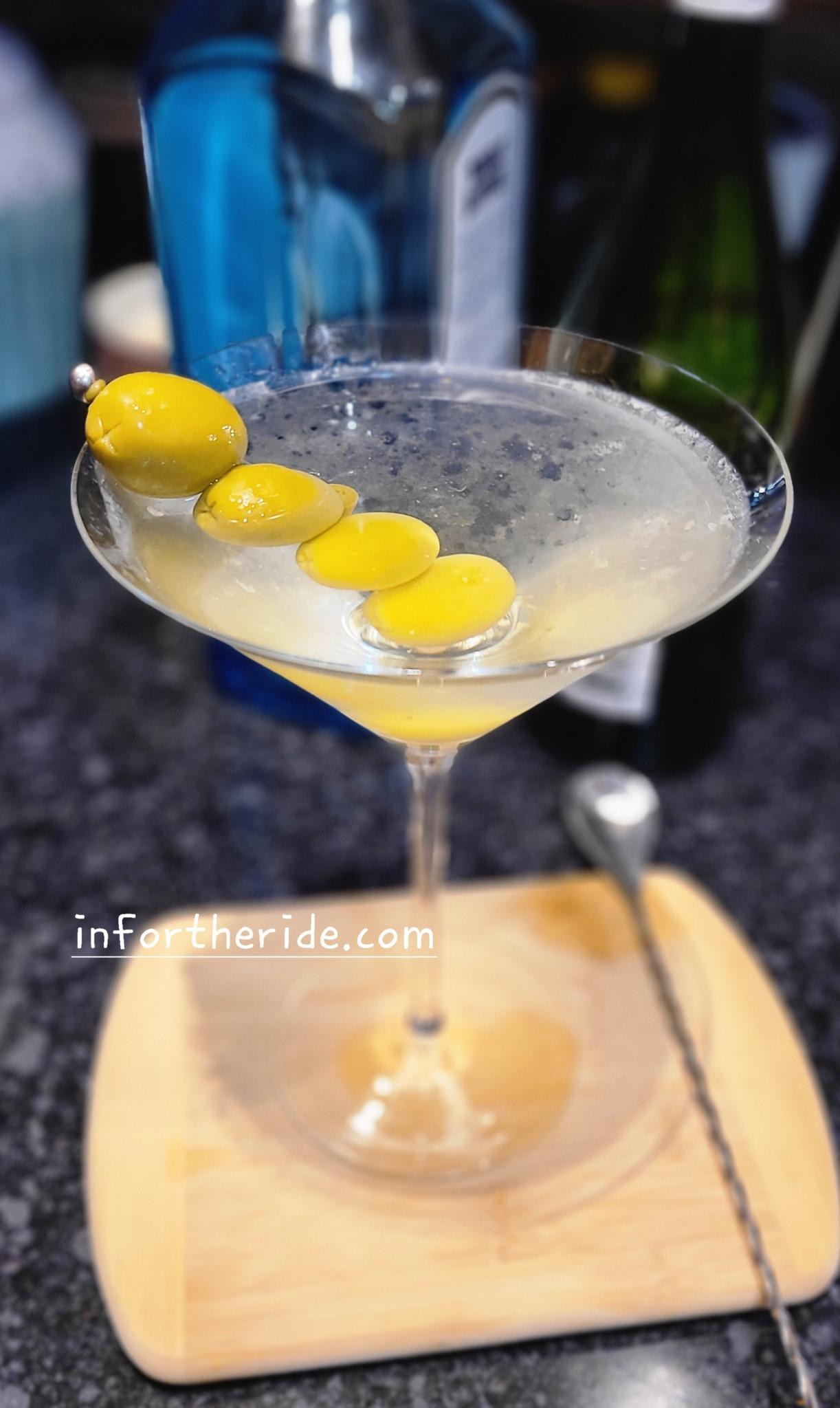 photo of dirty gin martini with 4x jalapeño olives